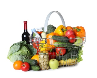 Photo of Shopping basket and grocery products on white background