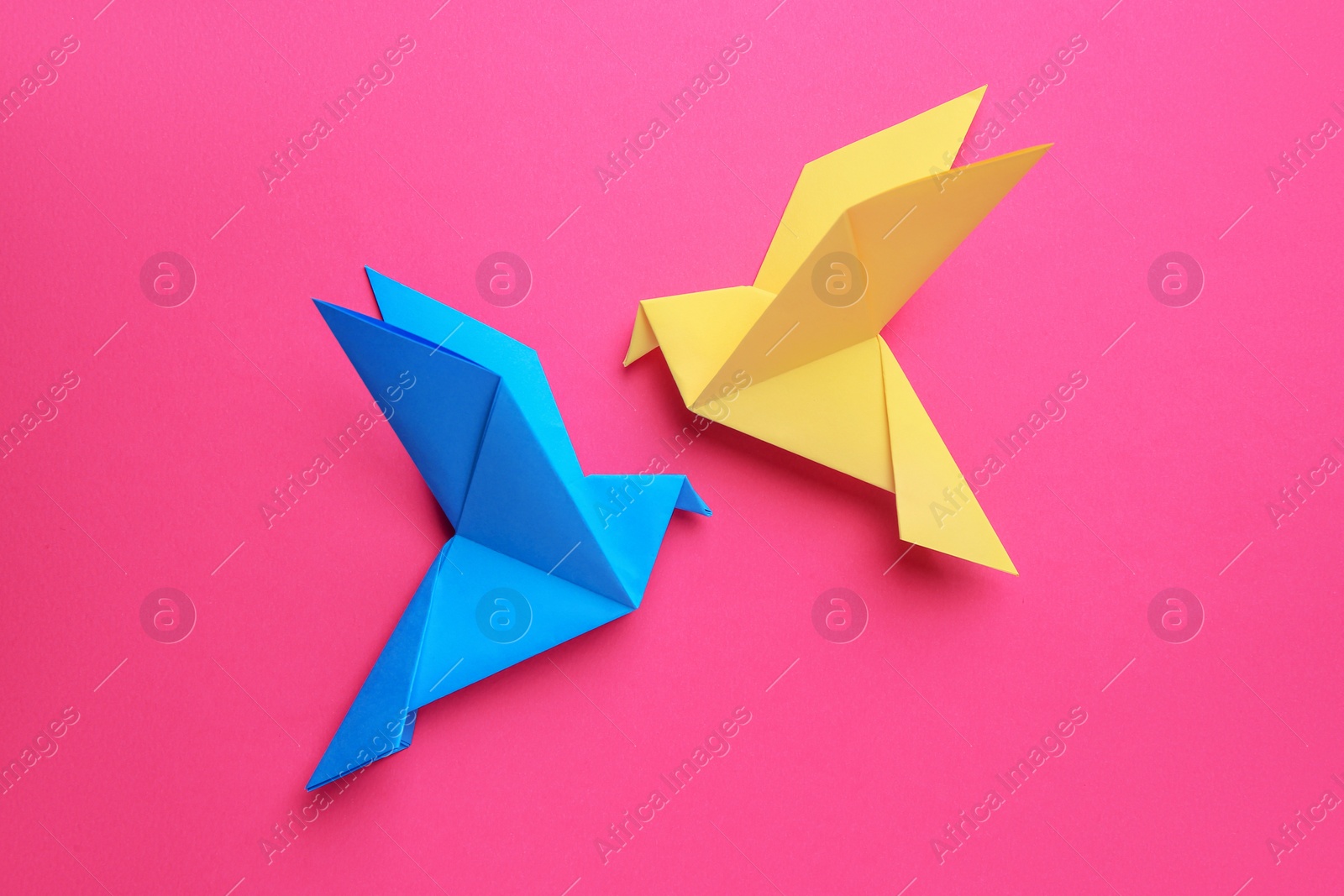 Photo of Beautiful colorful origami birds on pink background, flat lay