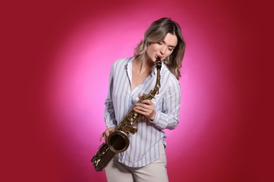 Photo of Beautiful young woman playing saxophone on red background