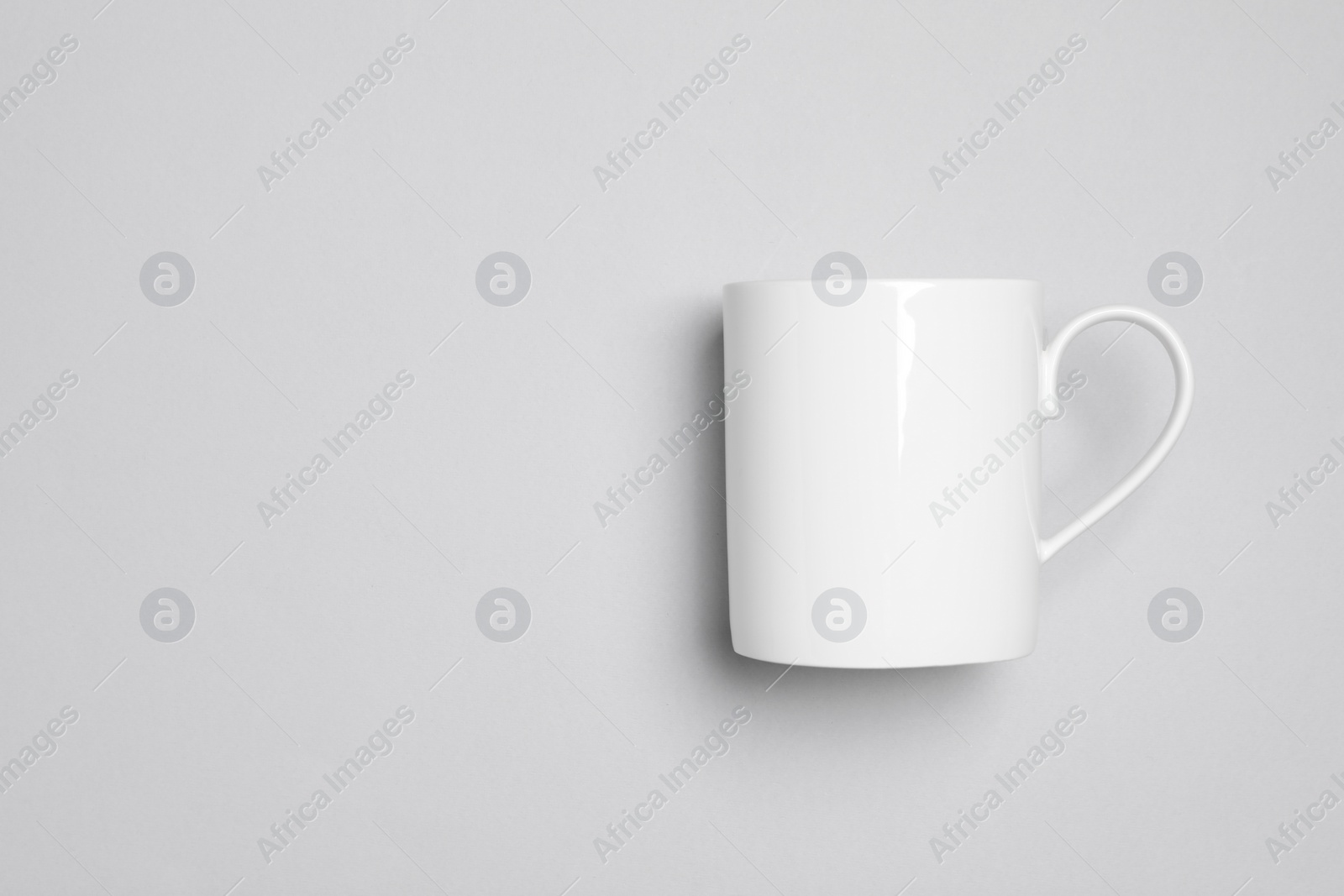One white ceramic mug on light background, top view and space for text Photo of One white ceramic mug on light background, top view and space for text