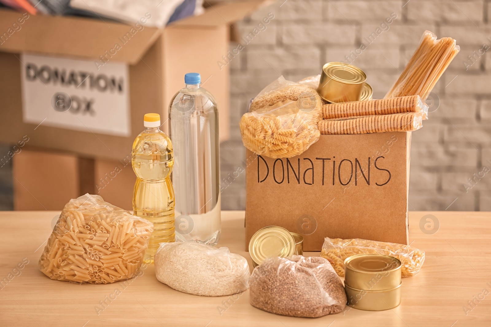 Photo of Donation box with food on table against brick wall