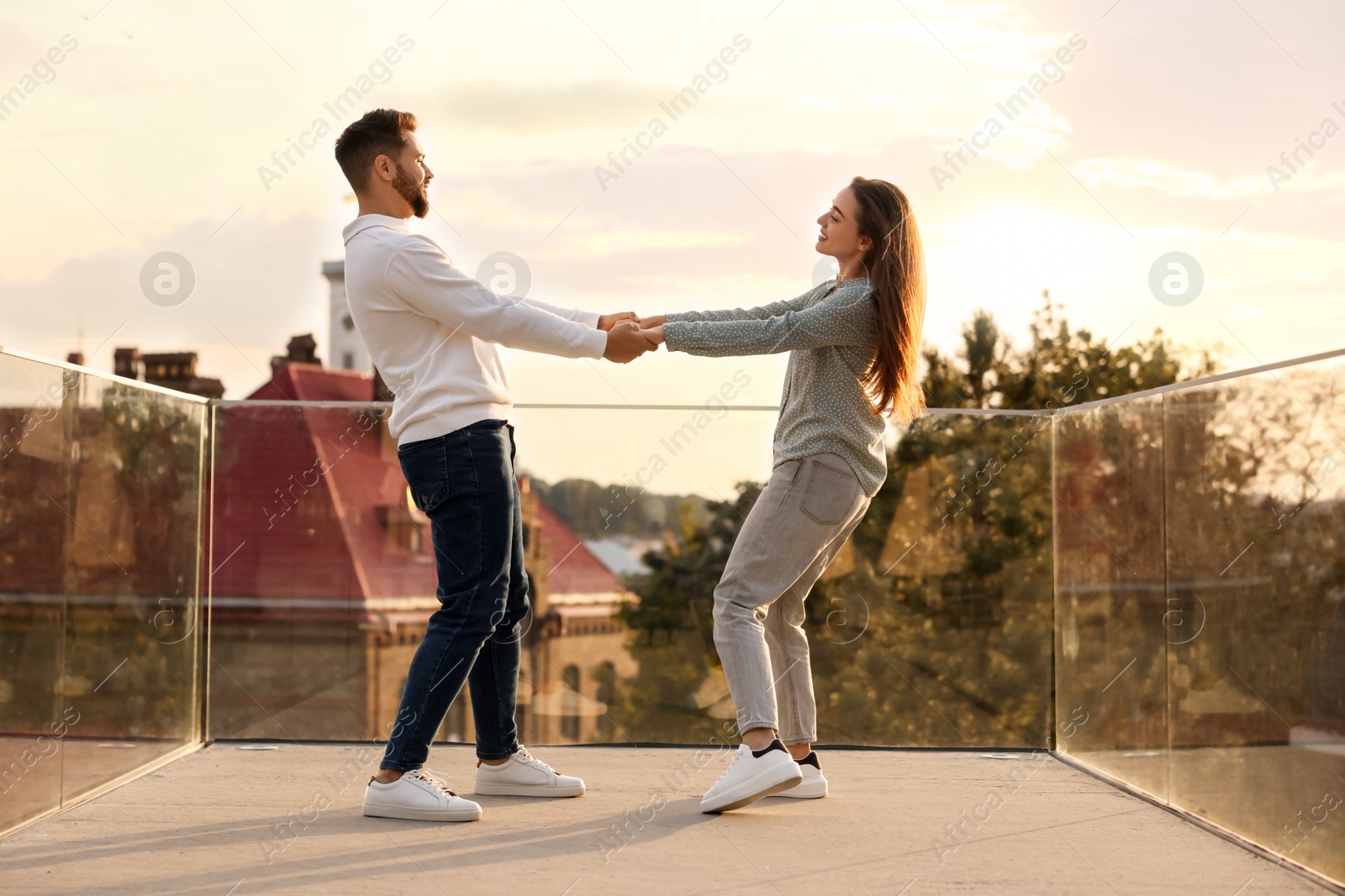 Photo of Lovely couple dancing together outdoors at sunset