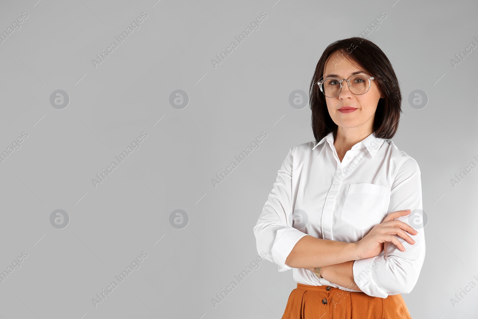 Photo of Portrait of mature businesswoman on light grey background. Space for text