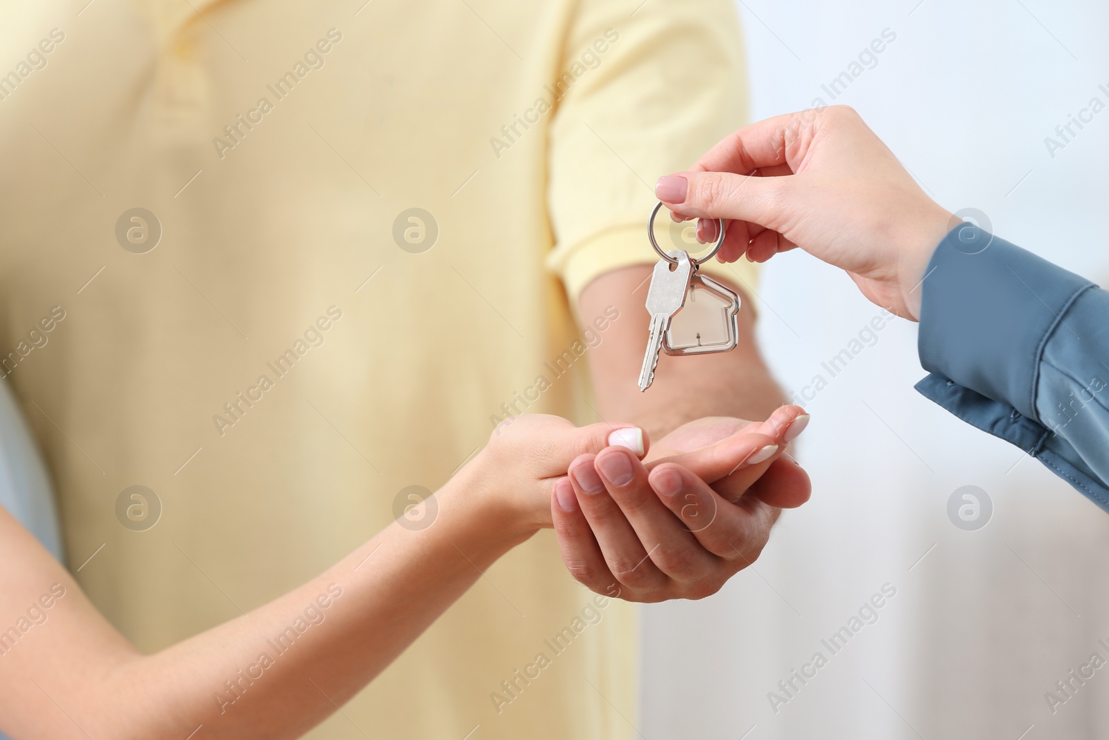 Photo of Real estate agent giving house key to couple, closeup