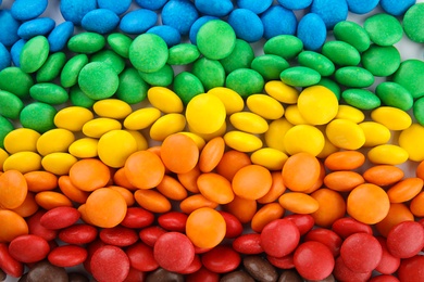 Many colorful candies as background, top view