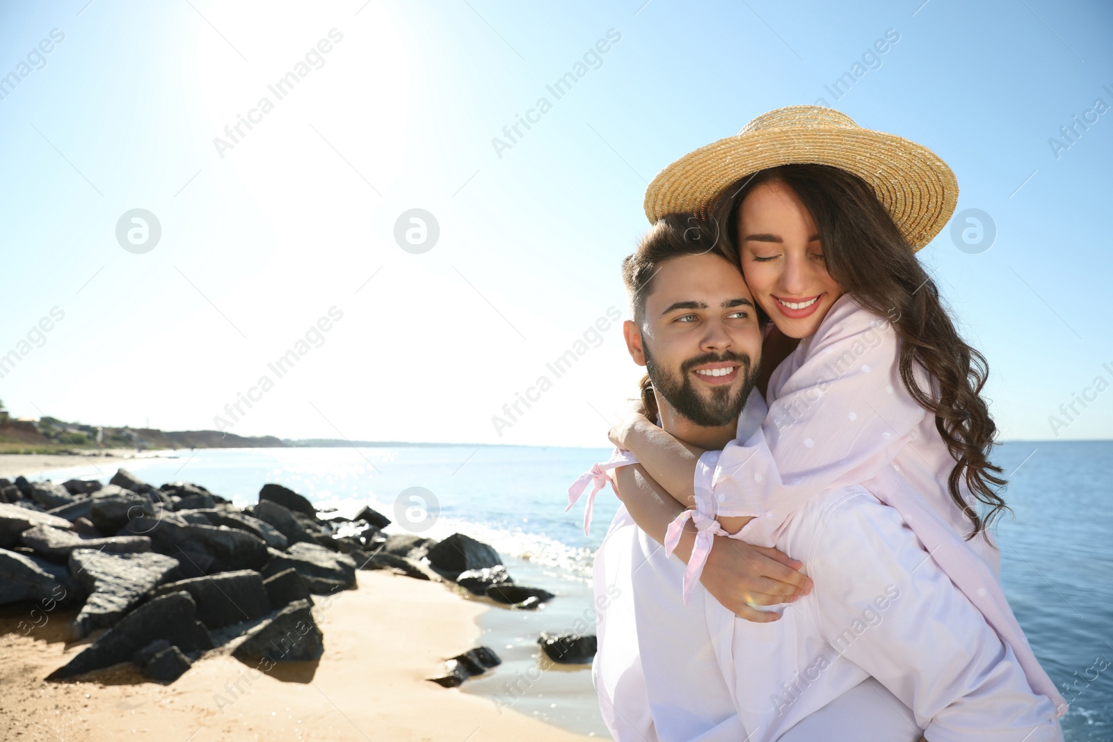 Photo of Happy young couple having fun at beach near sea. Honeymoon trip