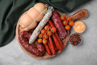 Photo of Different types of tasty sausages and ingredients on light grey table, flat lay