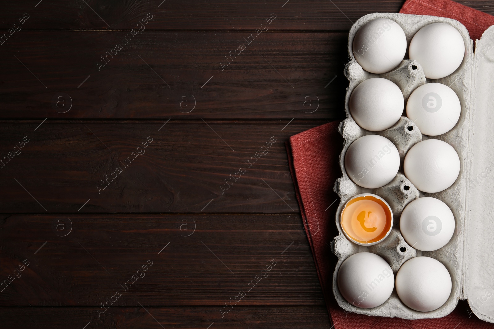 Photo of Fresh raw chicken eggs in box on wooden table, flat lay. Space for text