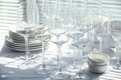 Set of empty wine glasses and dishware on table indoors