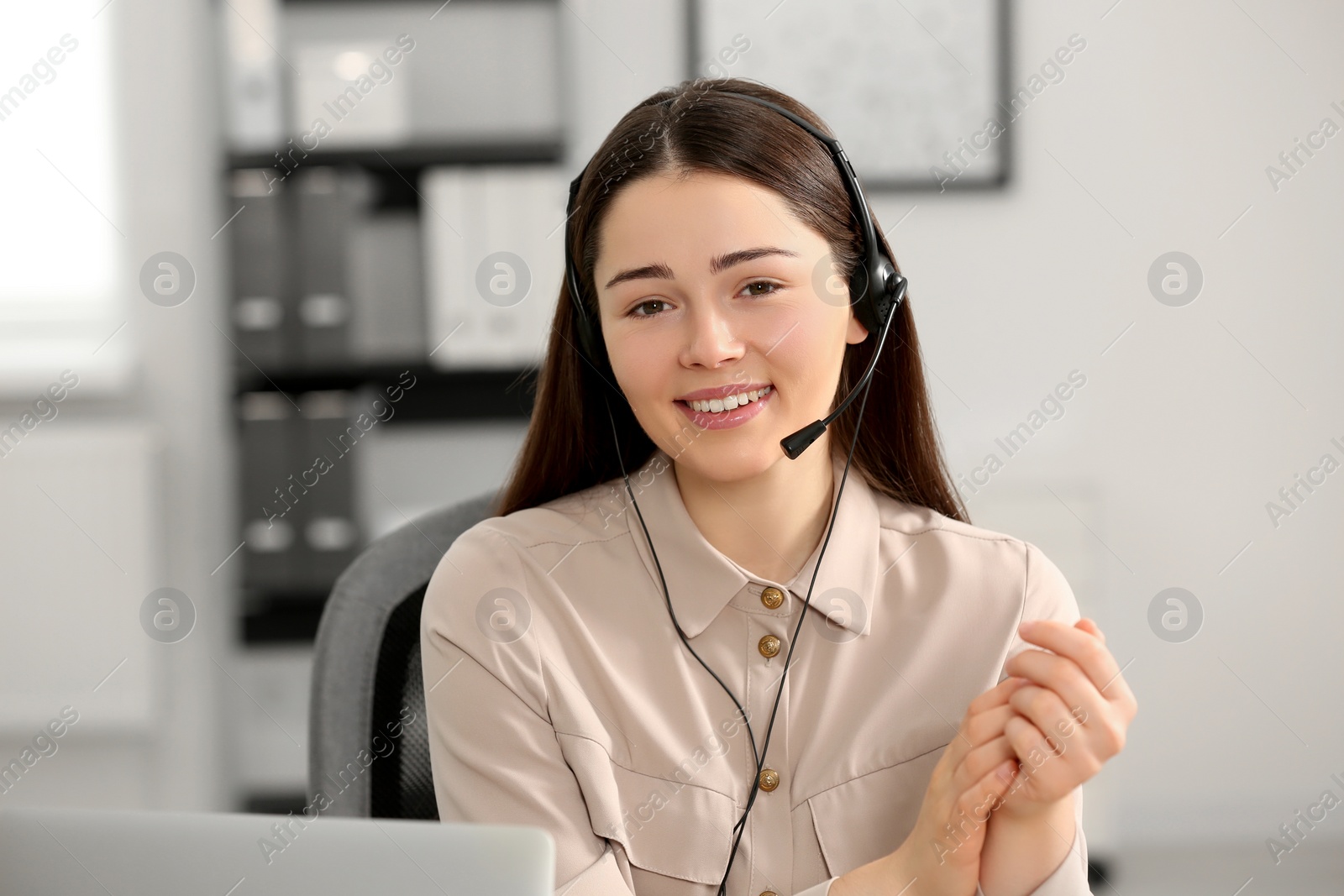 Photo of Hotline operator with headset working in office