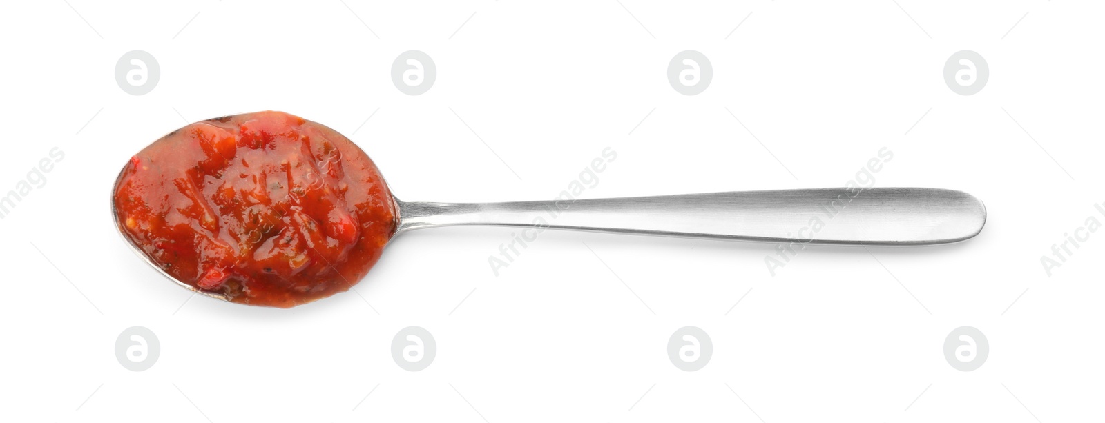 Photo of Delicious adjika sauce in spoon isolated on white, top view