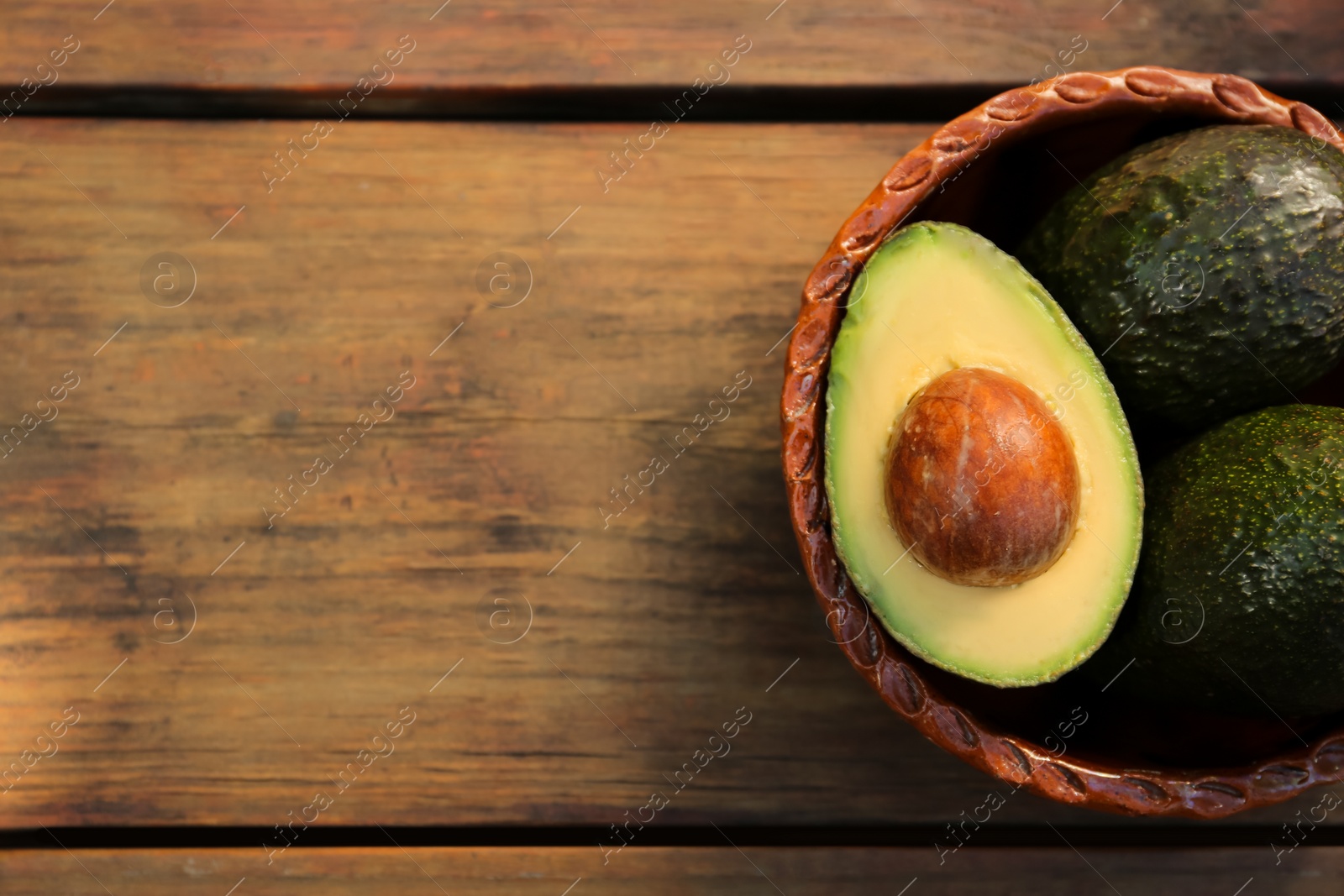 Photo of Tasty fresh avocados on wooden table, top view. Space for text