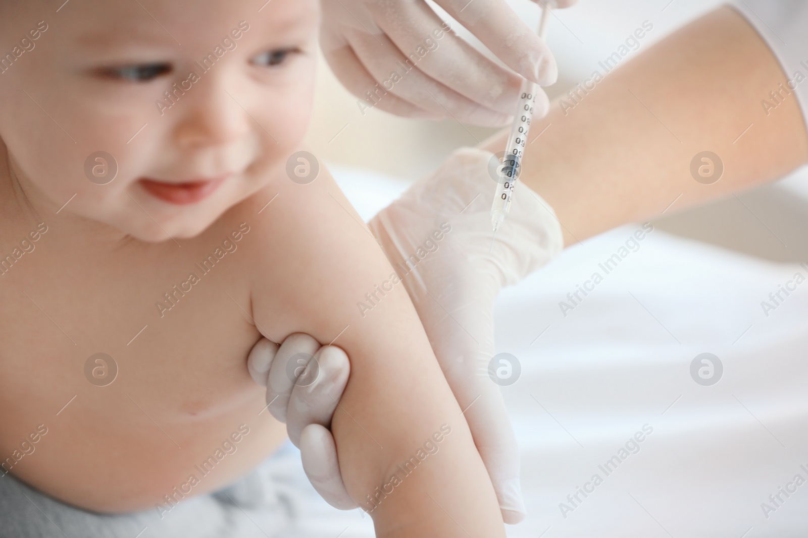 Photo of Doctor vaccinating baby in clinic, closeup