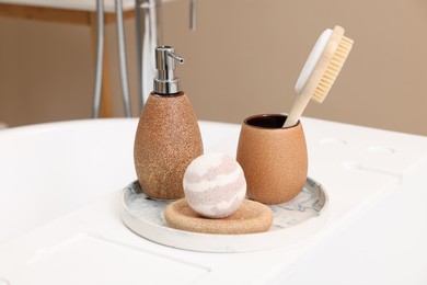 Photo of Different personal care products and accessories on bath tub in bathroom, closeup