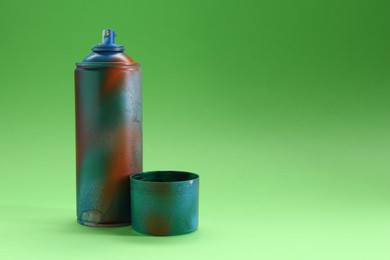 Photo of Spray paint can with cap on green background, space for text