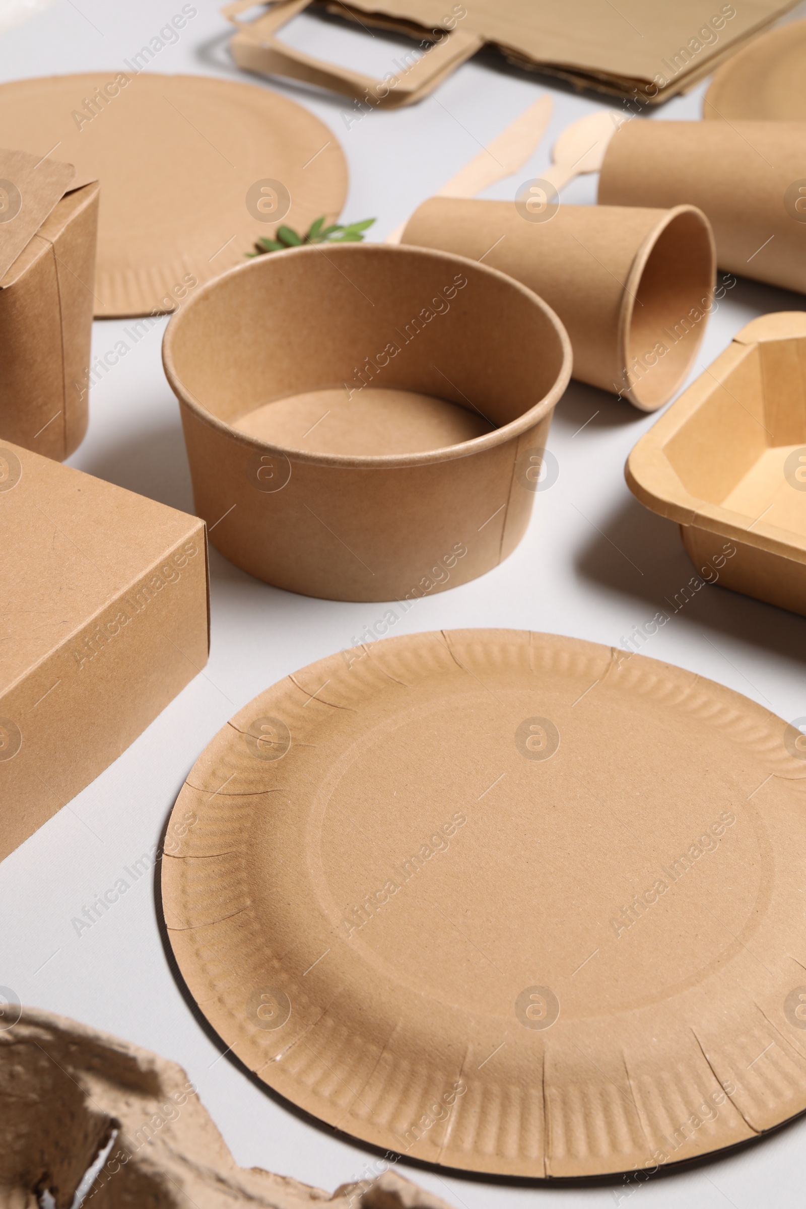 Photo of Eco friendly food packaging. Paper containers and tableware on light grey background