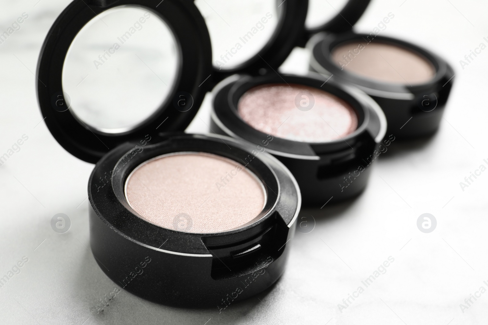 Photo of Different eye shadows on marble table, closeup