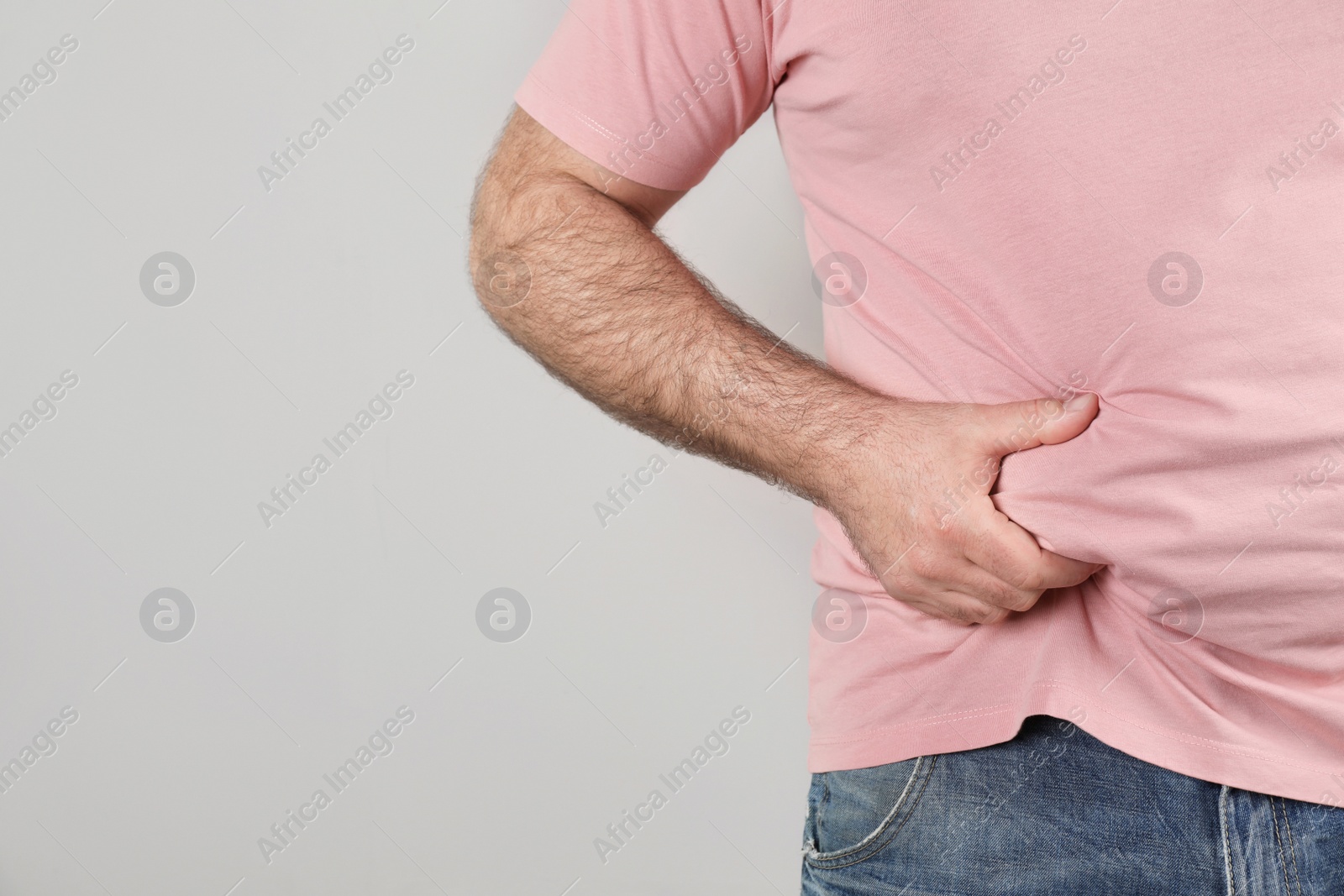 Photo of Overweight man with large belly on color background, closeup. Space for text
