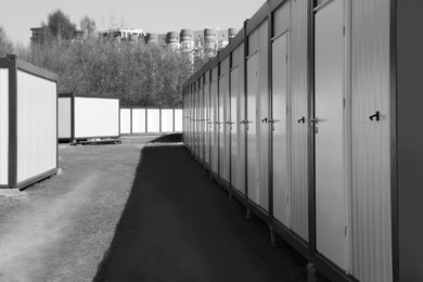 Photo of New modular houses for internally displaced persons outdoors. Black and white effect