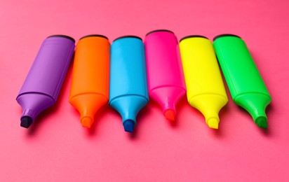 Photo of Many different color markers on pink background