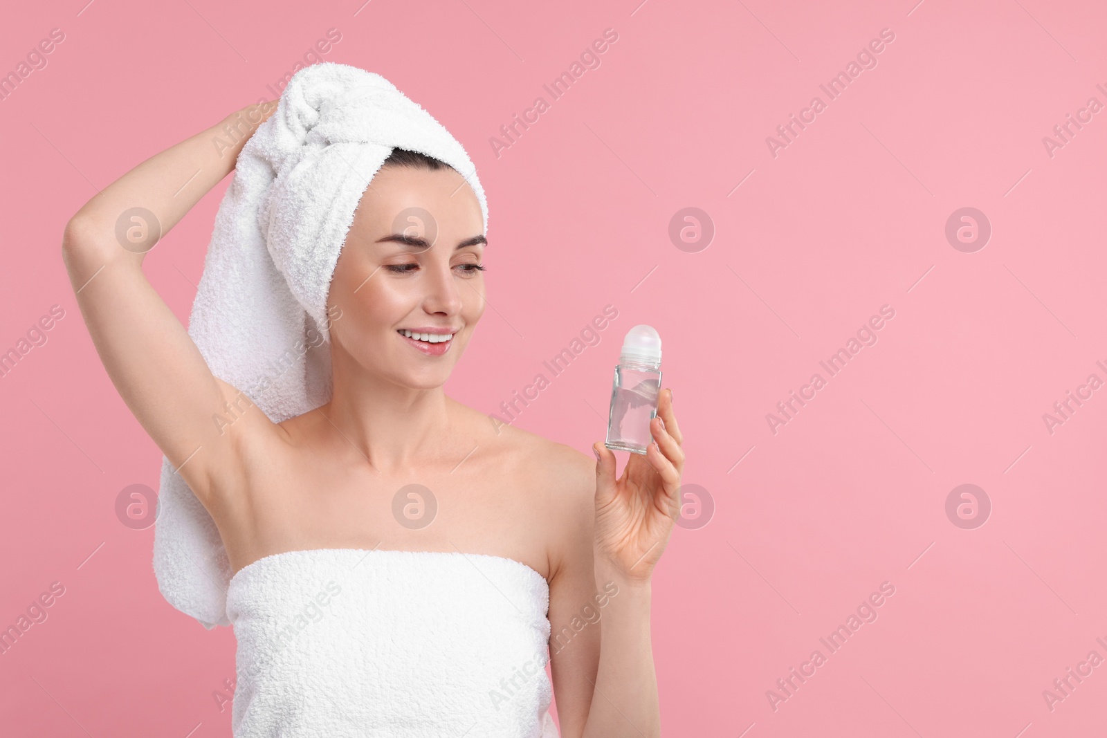 Photo of Beautiful woman with deodorant on pink background, space for text