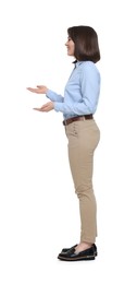 Happy businesswoman in blue shirt and beige pants on white background