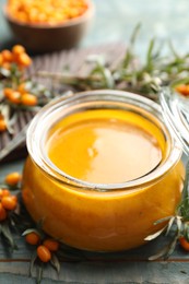 Photo of Delicious sea buckthorn jam and fresh berries on wooden table