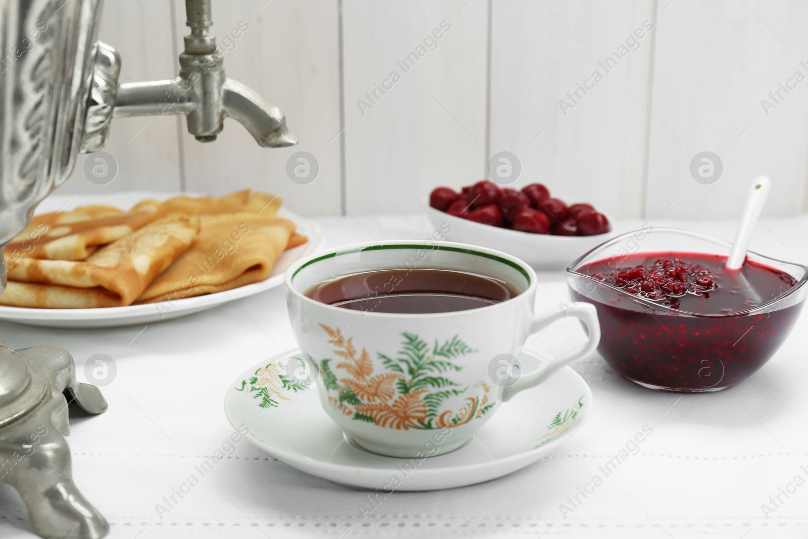 Photo of Cup of aromatic tea and treats on table