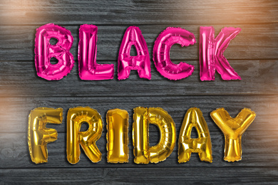 Phrase BLACK FRIDAY made of foil balloon letters on grey wooden background