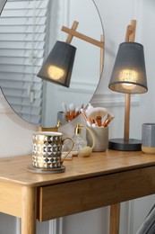 Mug of hot drink with stylish cup coaster on dressing table in room