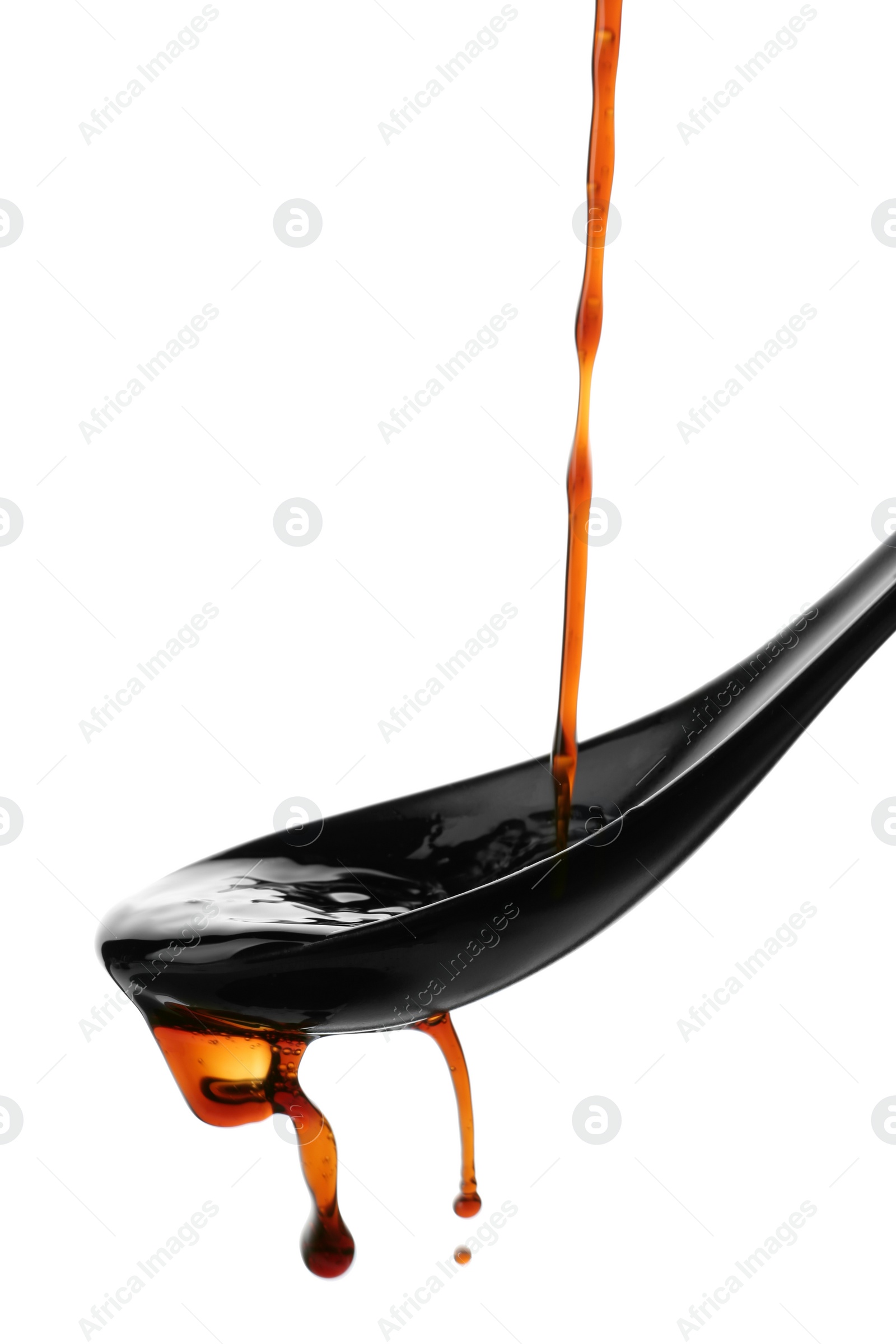 Photo of Pouring soy sauce into spoon against white background