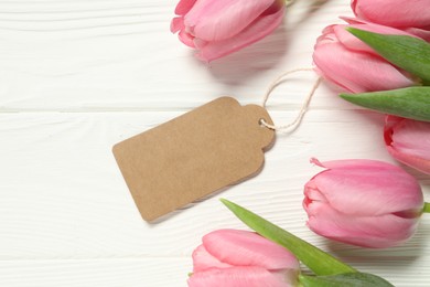 Photo of Happy Mother's Day. Beautiful tulips with blank card on white wooden table, flat lay