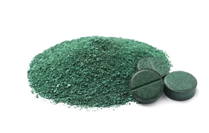 Pile of spirulina powder and pills on white background