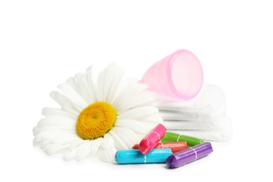 Photo of Tampons, pads, menstrual cup and chamomile flower on white background