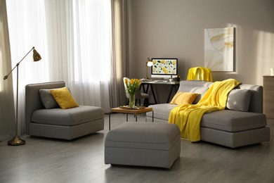 Photo of Stylish living room with sofa. Interior design in grey and yellow colors