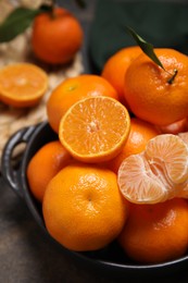 Photo of Fresh juicy tangerines on black table, closeup