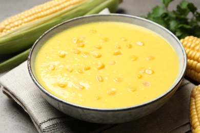 Photo of Delicious creamy corn soup on grey table, closeup