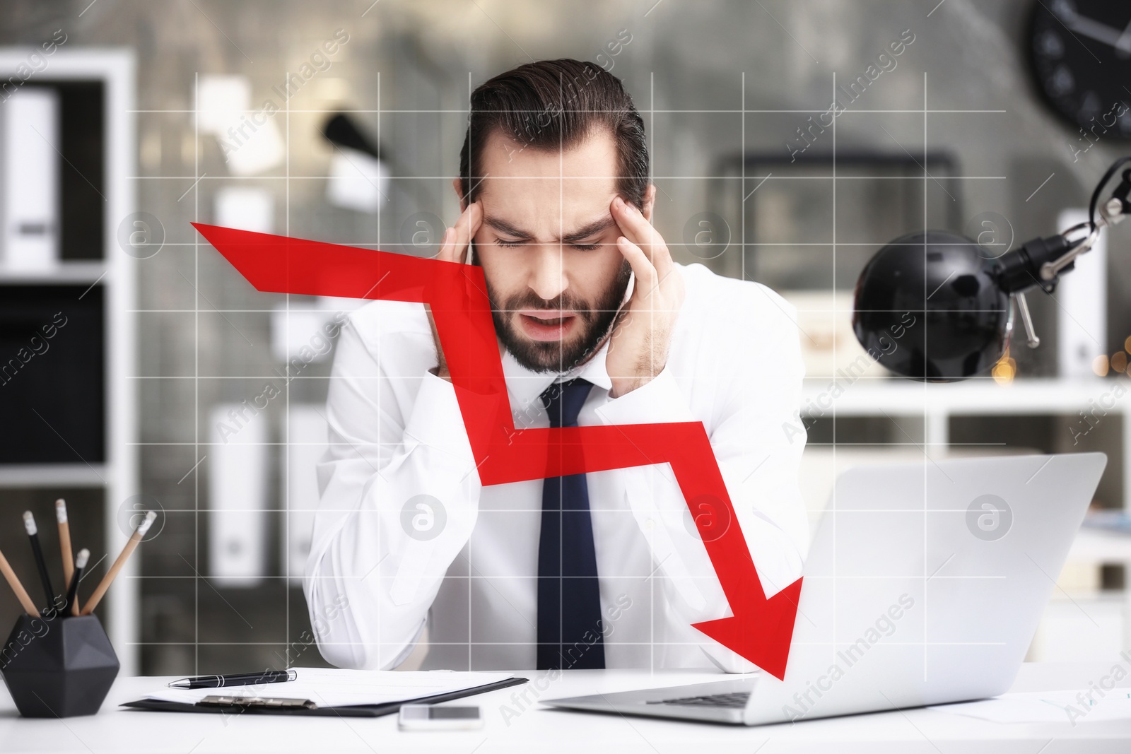 Image of Stressed businessman at table in office and illustration of falling down chart. Economy recession concept