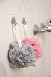 Photo of Shower puffs hanging near faucet in bathroom