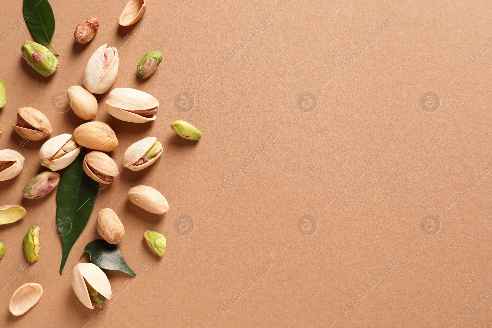 Photo of Composition with organic pistachio nuts on color background, flat lay. Space for text