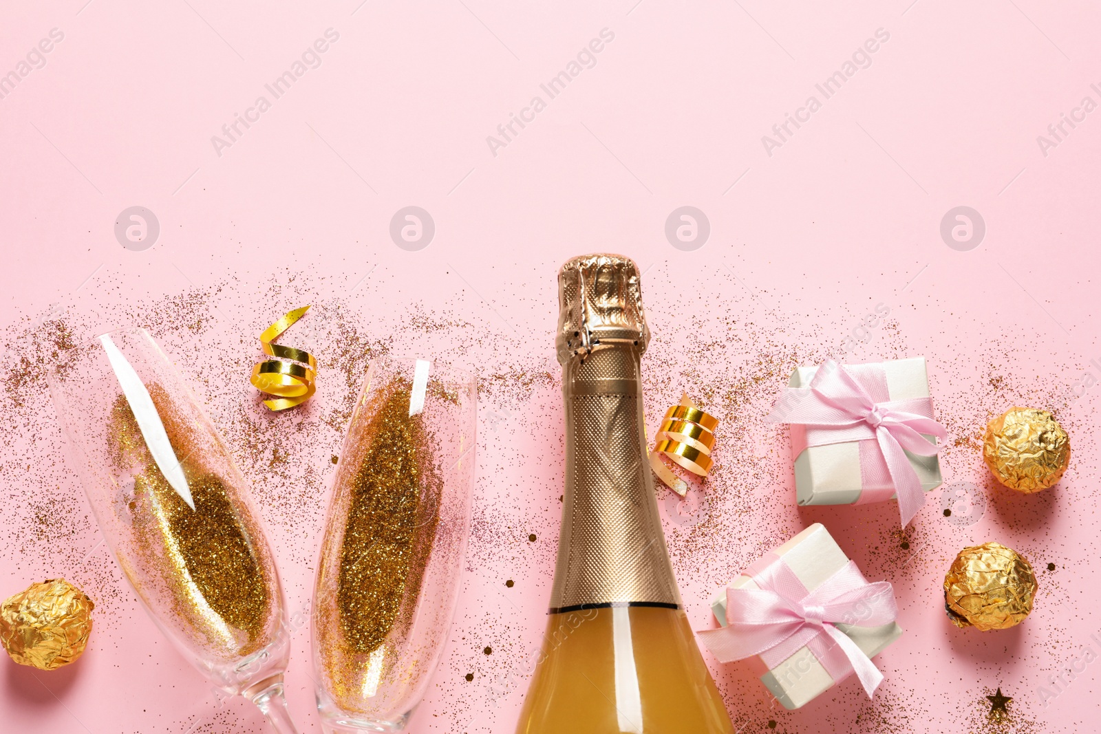 Photo of Flat lay composition with bottle of champagne for celebration on pink background