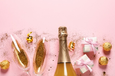 Flat lay composition with bottle of champagne for celebration on pink background