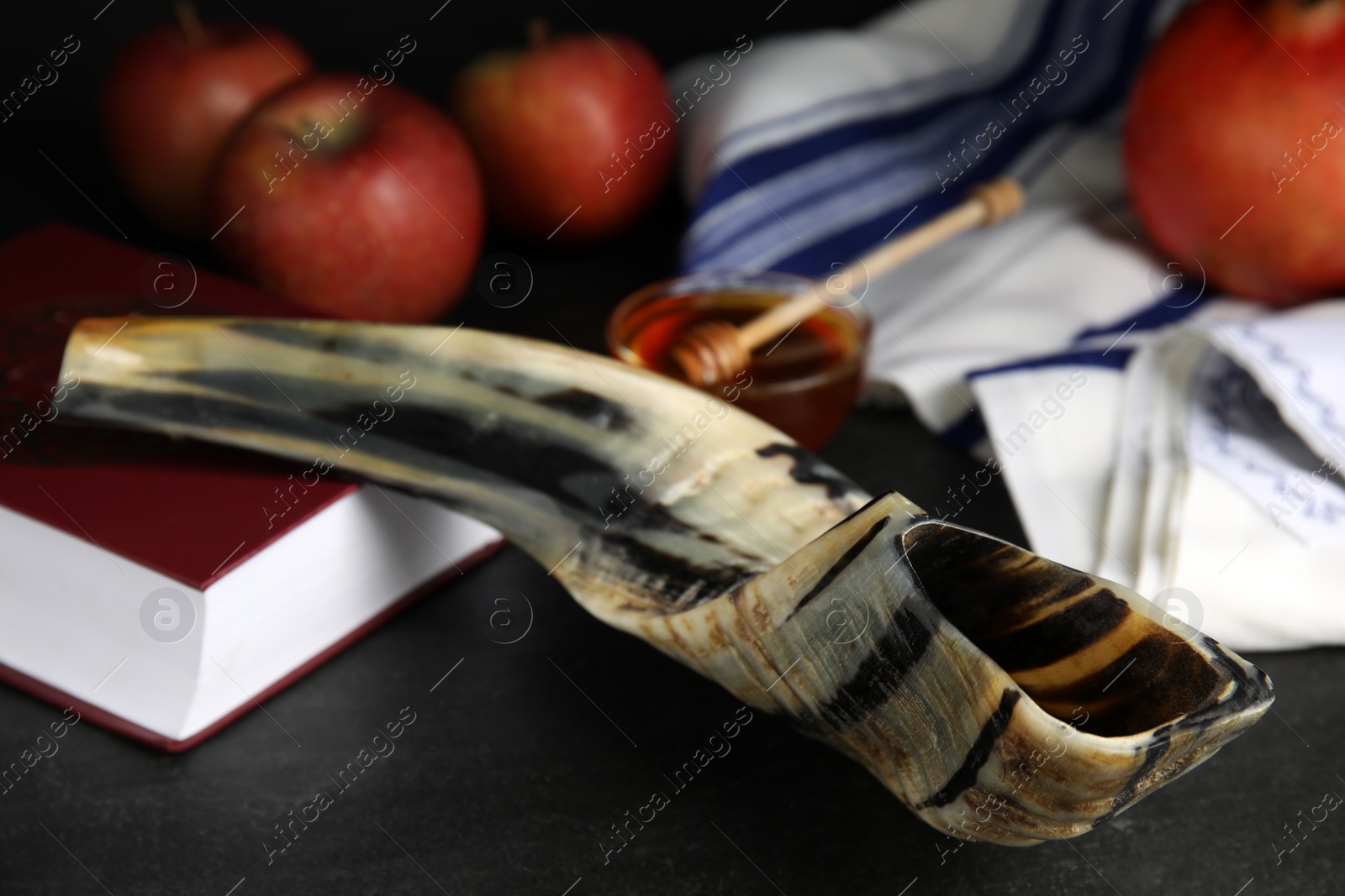 Photo of Shofar and Torah on black table, closeup. Rosh Hashanah celebration