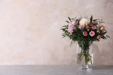 Photo of Beautiful bouquet with roses on table against grey background, space for text