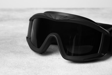 Photo of Tactical glasses on light gray background, closeup. Military training equipment