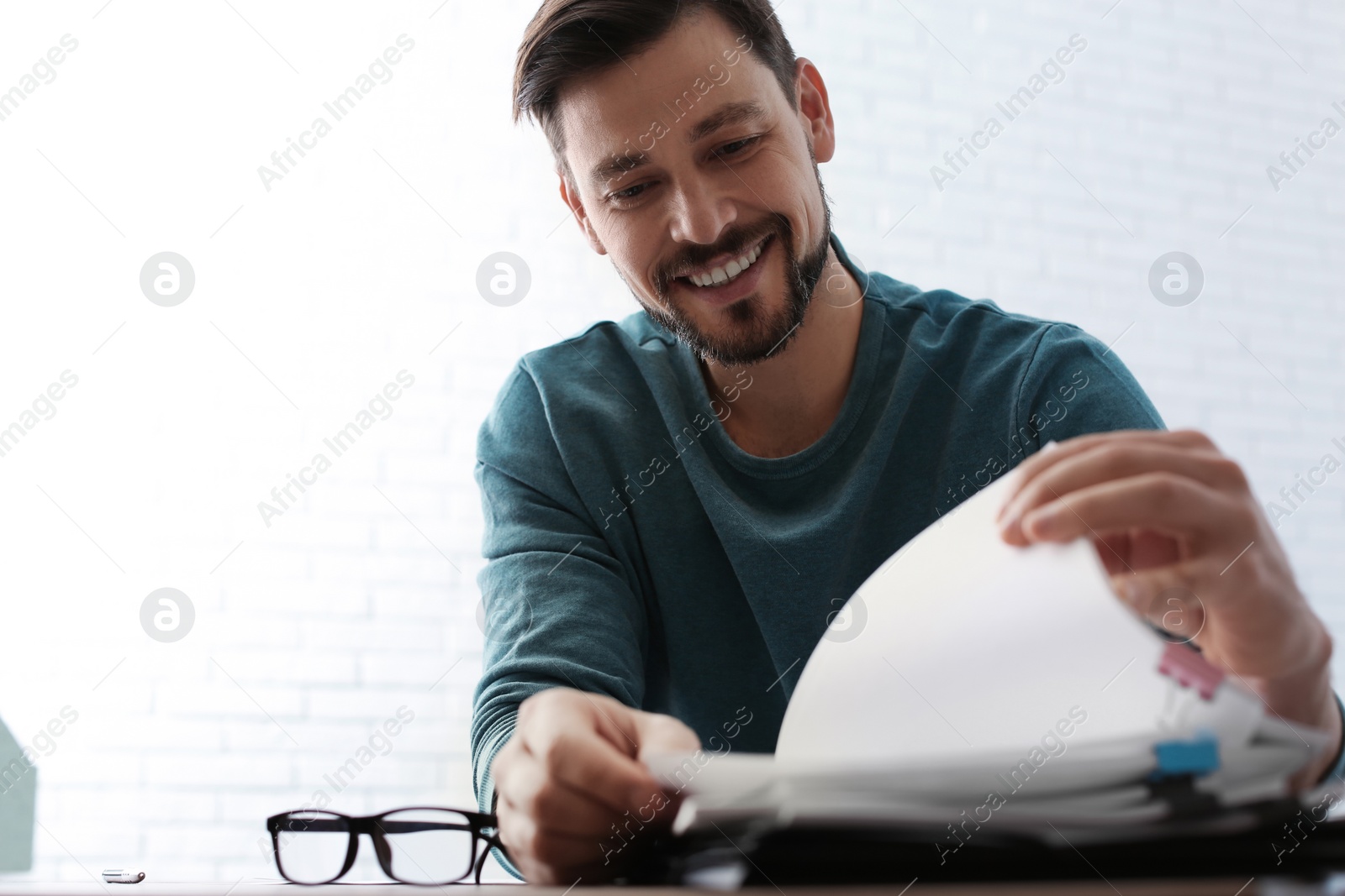 Photo of Man working with documents at table in office