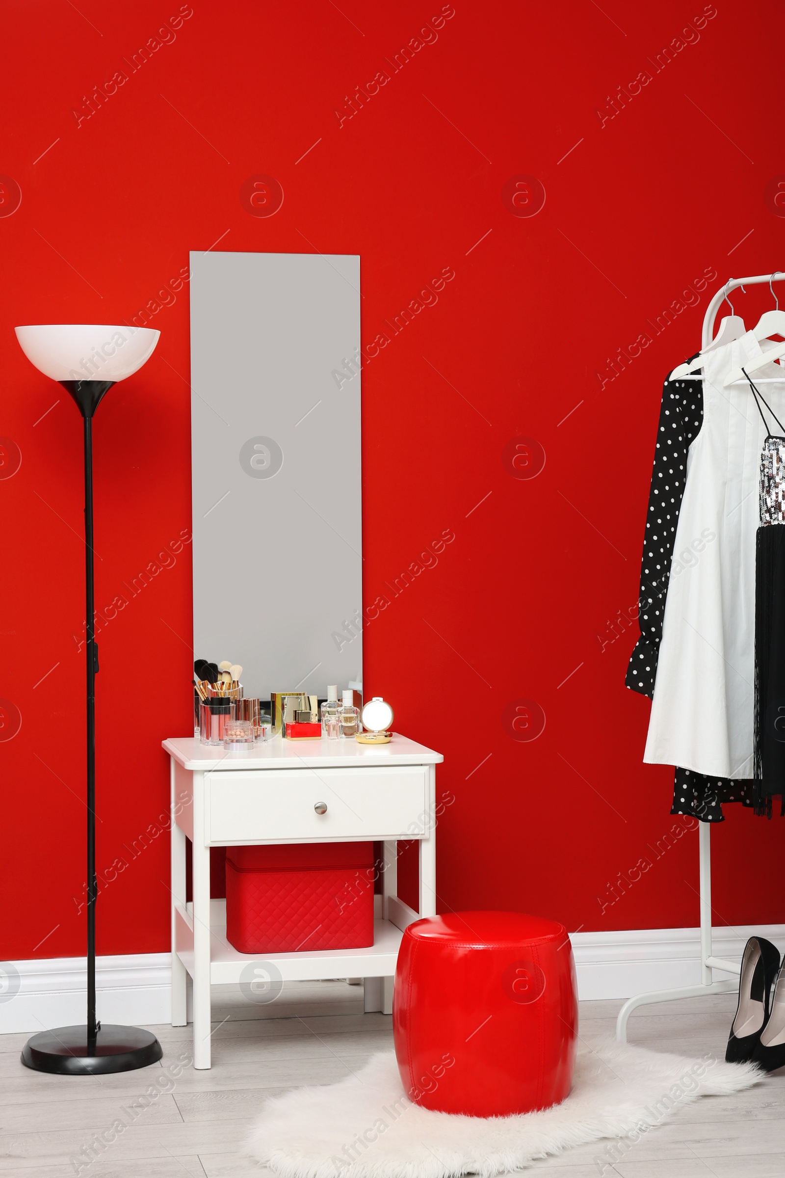 Photo of Stylish room interior with set of makeup products on dressing table