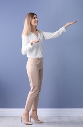 Female business trainer on near color wall