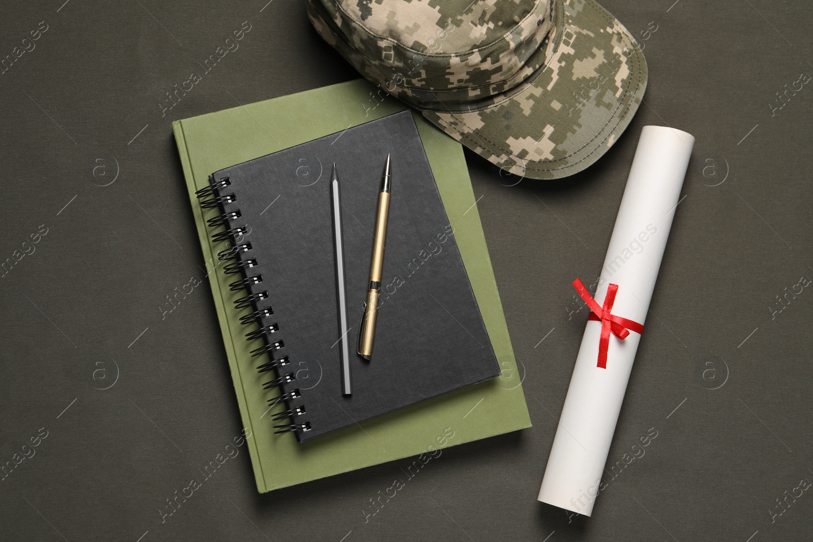 Photo of Stationery, soldier cap and diploma on dark background, flat lay. Military education