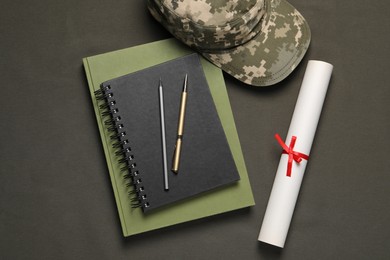 Stationery, soldier cap and diploma on dark background, flat lay. Military education